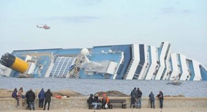 costa concordia inclinata con curiosi a terra